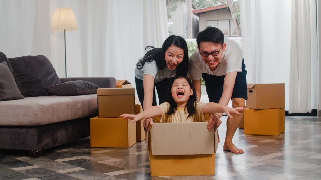 Happy-Asian-Young-Family-Having-Fun-Laughing-Moving-Into-New-Home-Japanese-Parents-Mother-Father-Smiling-Helping-Excited-Little-Girl-Riding-Sitting-Cardboard-Box-New-Property-Relocation_7861-2305  - Fe Credit